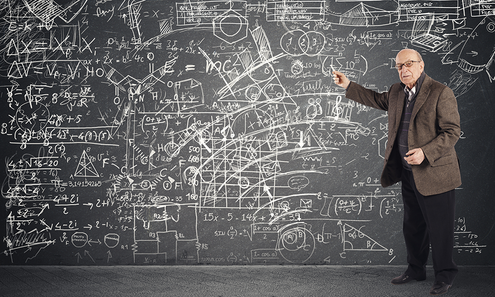 Professor in front of a chalkboard full of confusing and overlapping diagrams and mathematical equations.